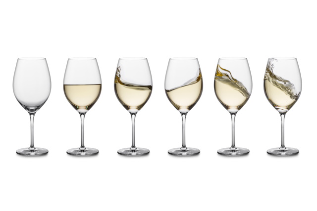 Glasses of white wine in a row on white background with various swirling patterns